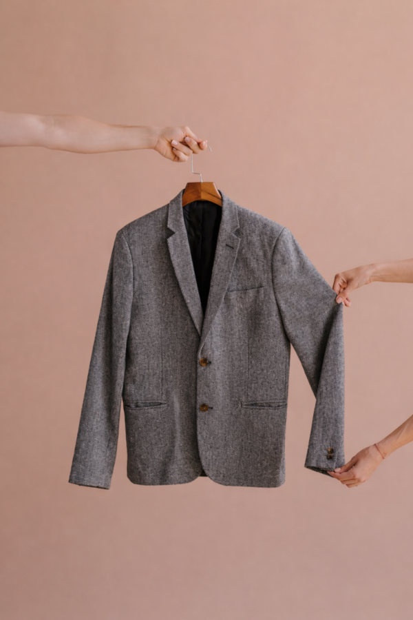 Blazer éthique gris intemporel suspendu sur cintre, élégant et conçu dans une démarche responsable