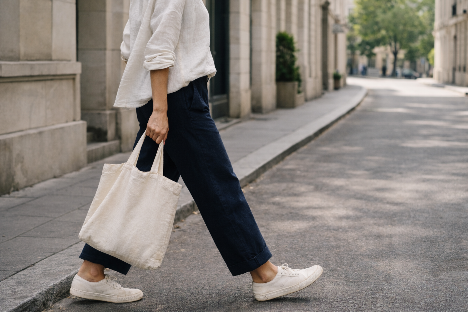 Personne marchant dans une rue urbaine en portant des vêtements simples et durables, illustrant une mode éthique et responsable.